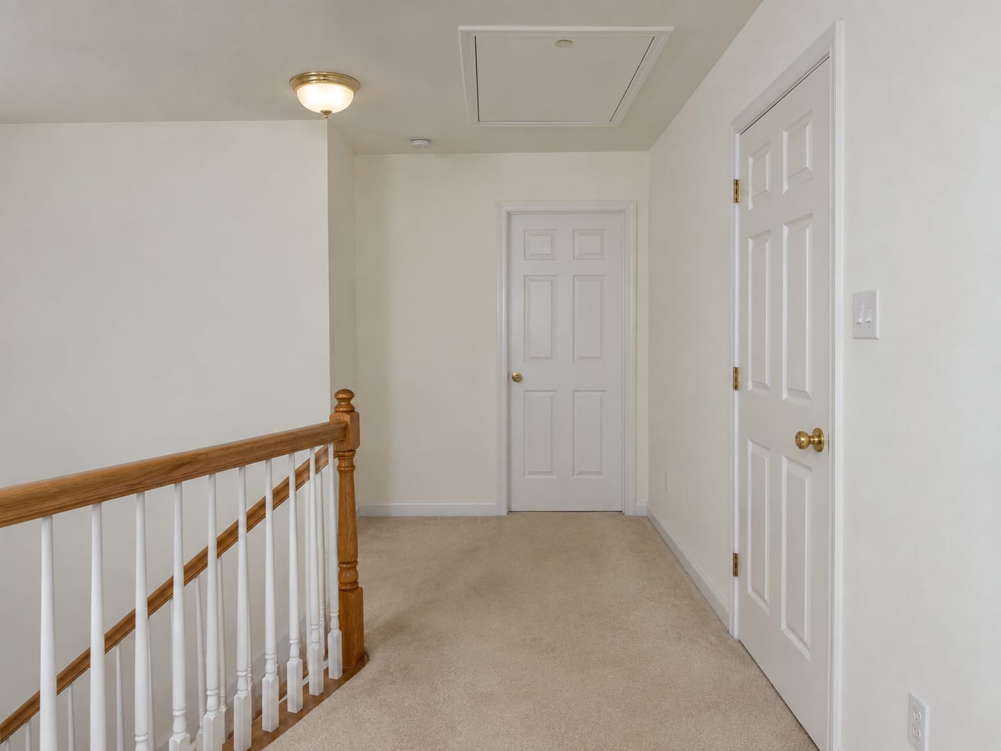 Second-floor hallway in a Robbinsville, New Jersey house with a painted attic access hatch in the ceiling