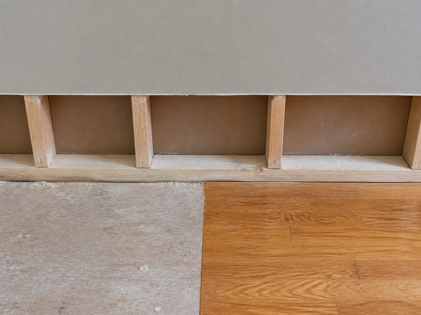 A close view of a removal boundary in an East Windsor townhome where the drywall and baseboard were taken back to a straight square cut line and the flooring stops at the same line on the bare subfloor