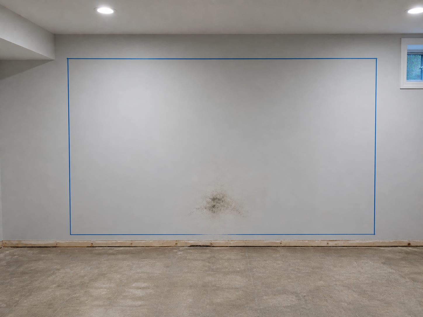 A chalk line snapped on a wall in a wide rectangle well outside a much smaller area of visible staining, marking the extent to be removed rather than the extent that can be seen, in Alpine, New Jersey
