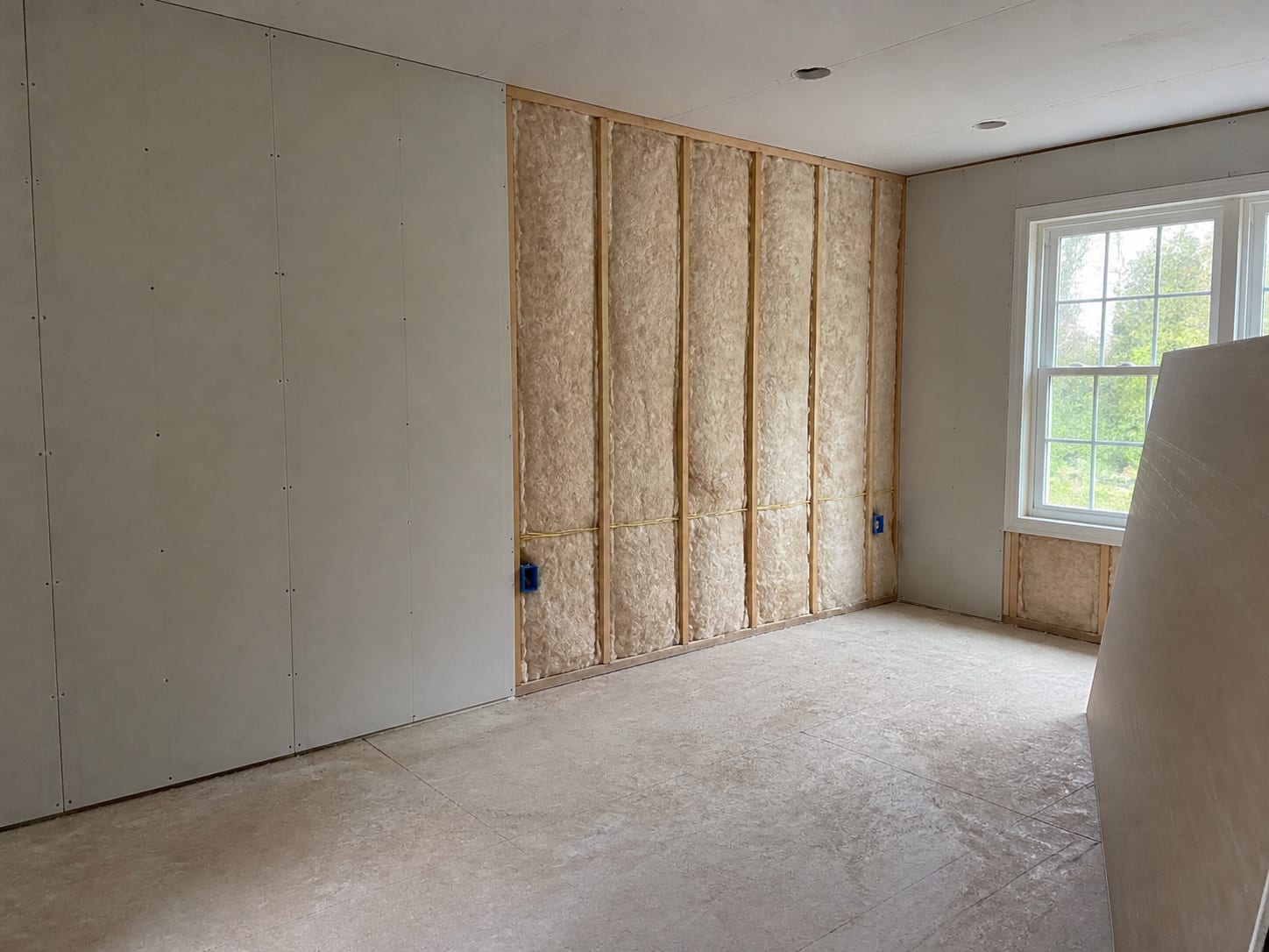 New drywall sheets set in place over fresh insulation and services in a West Windsor, New Jersey room, with the adjoining bays still open