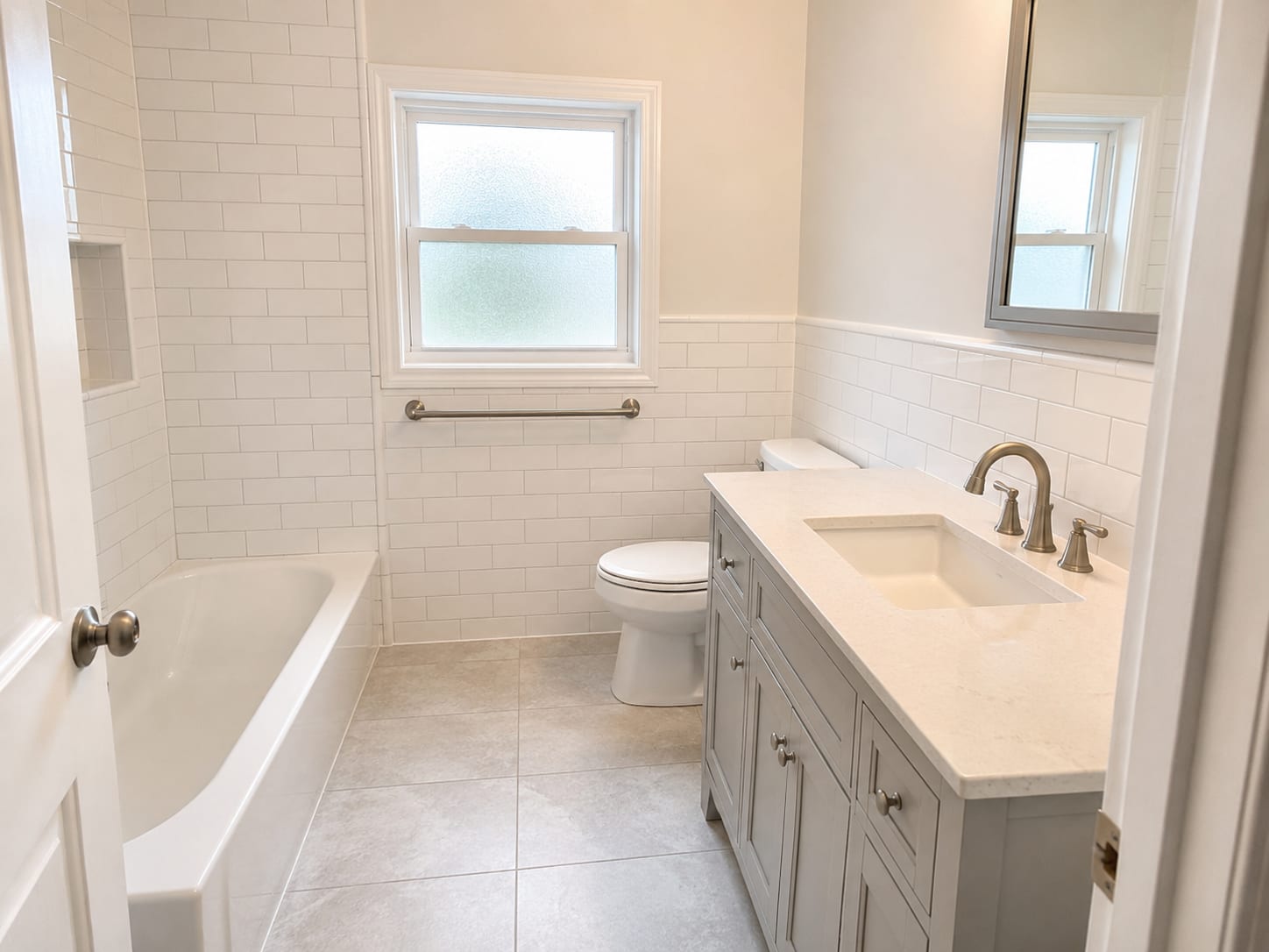 Fully renovated bathroom with new subway tile walls, clean grout lines, modern vanity, and natural light from a frosted window