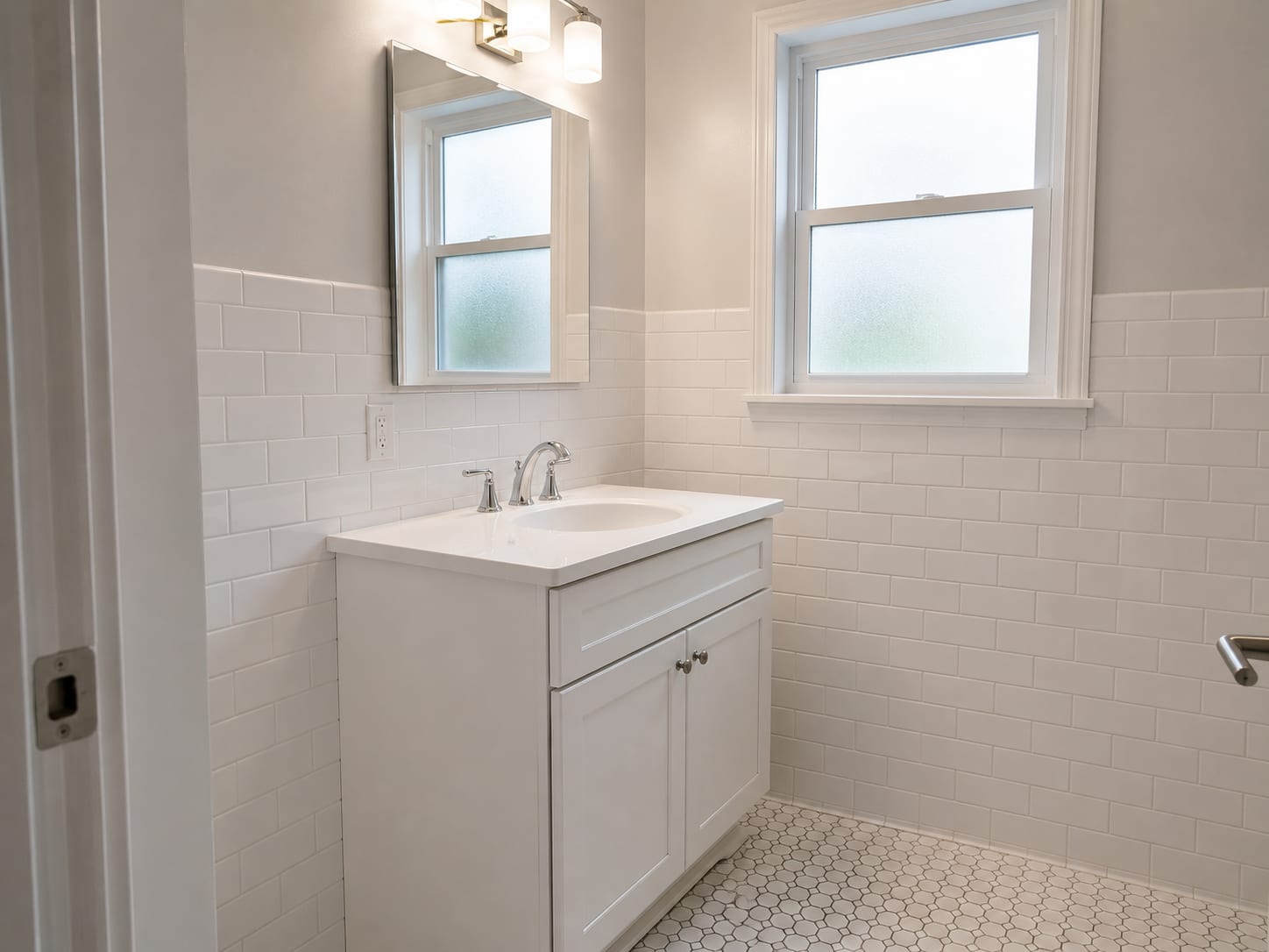 Newly rebuilt bathroom in a New Jersey colonial home showing fresh ceramic tile walls, a new vanity cabinet, and clean grout lines after full build-back restoration