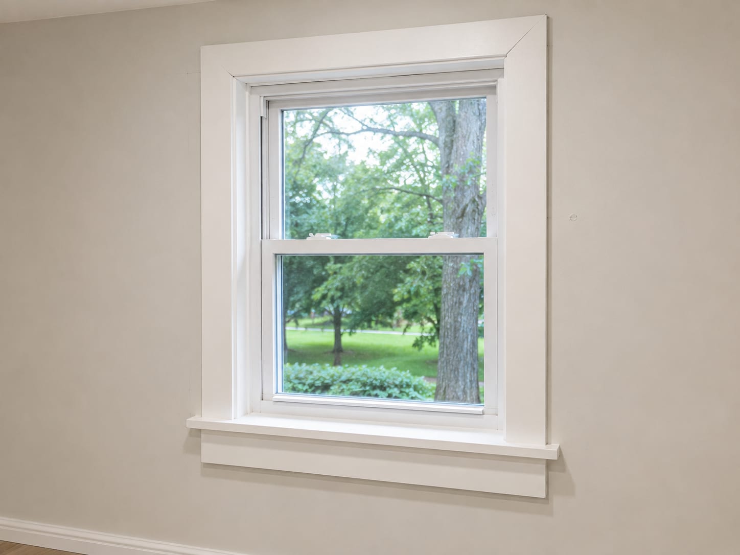 Newly installed flat-profile wood window casing around a double-hung window in a freshly drywalled New Jersey home interior showing clean paint and precise joinery