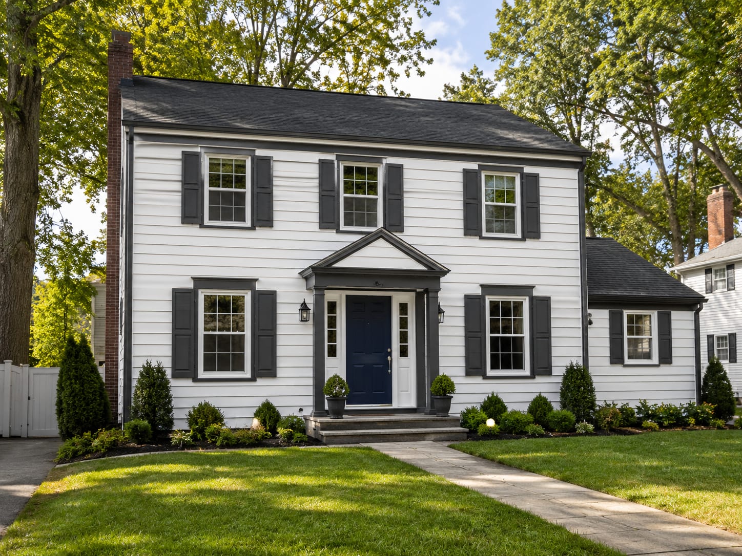 Freshly painted white and gray colonial home exterior with crisp trim and landscaped front yard in central New Jersey