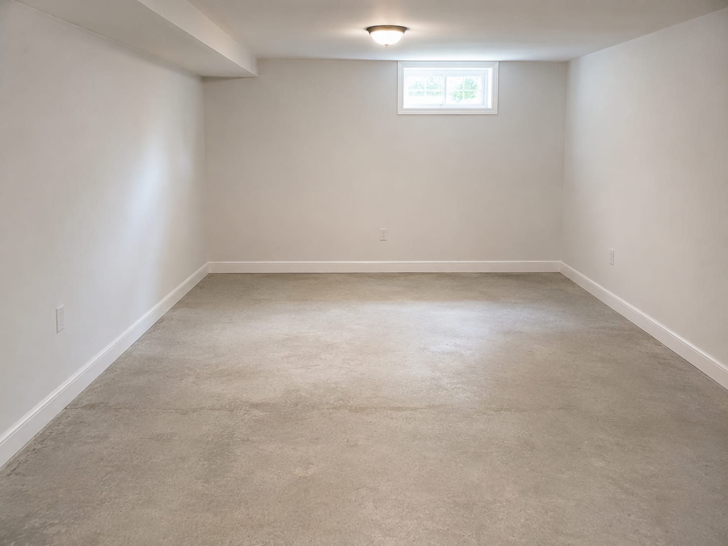 Fully restored and dried basement room in a New Jersey home showing fresh drywall, clean painted walls, dry concrete floor, and no signs of prior flood damage