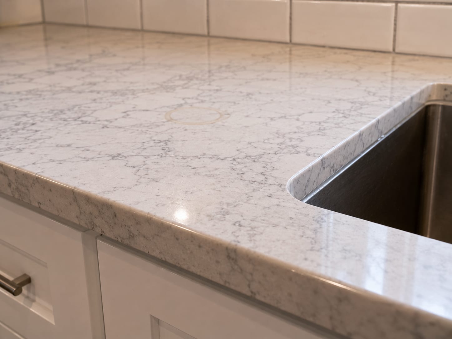 Close-up of a freshly installed quartz countertop edge with a new undermount sink cutout and polished eased edge profile in a renovated New Jersey kitchen