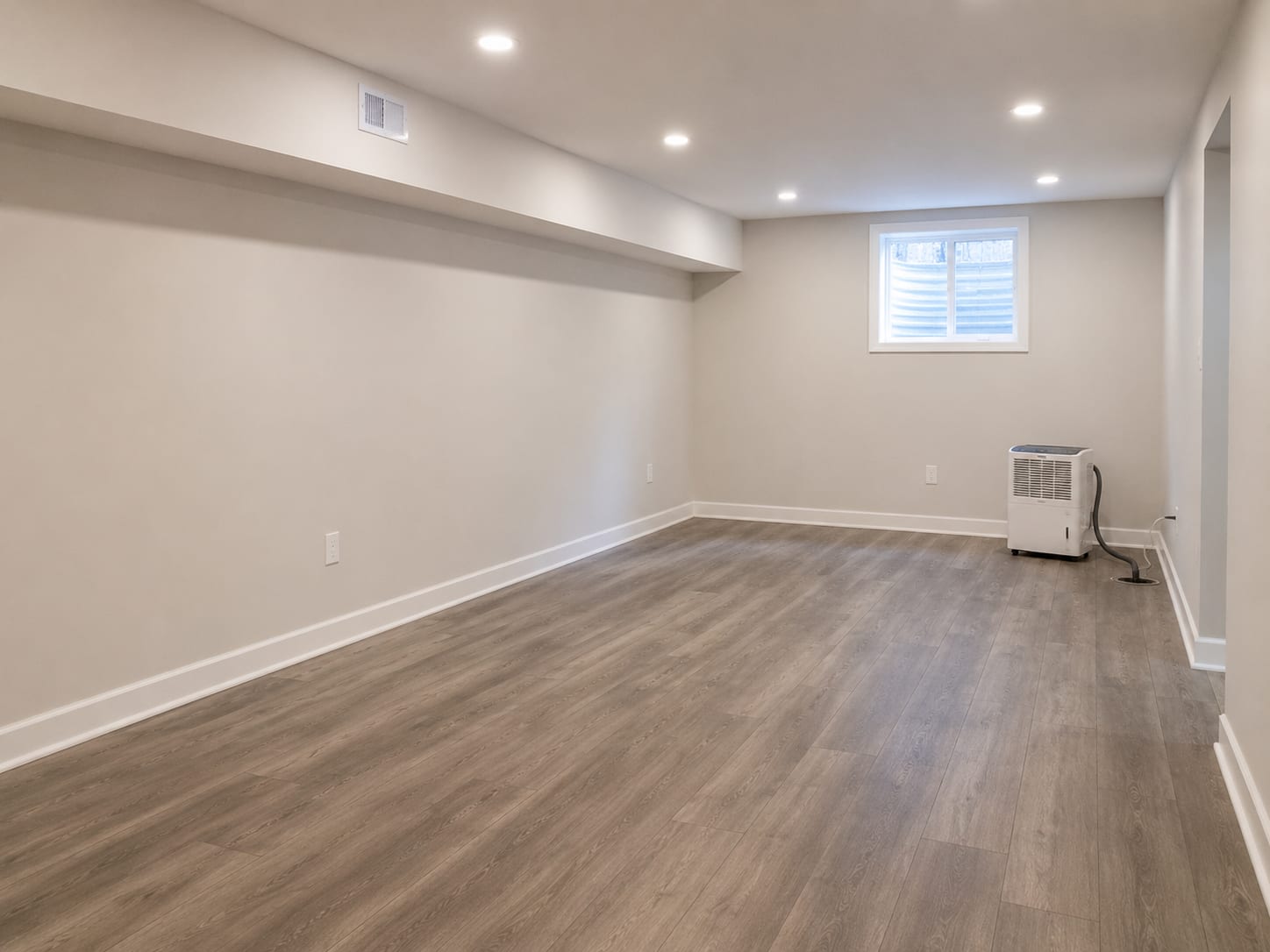 A clean dry finished basement interior in a New Jersey home after completed mold remediation showing fresh drywall and restored flooring