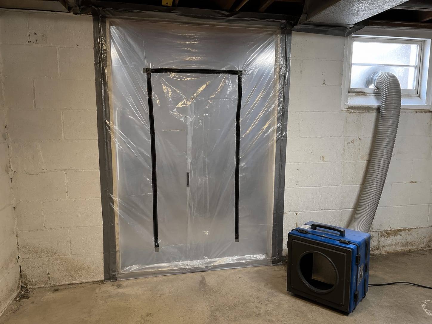 Plastic sheeting containment barrier sealing off a basement doorway in a New Jersey colonial home during active mold remediation