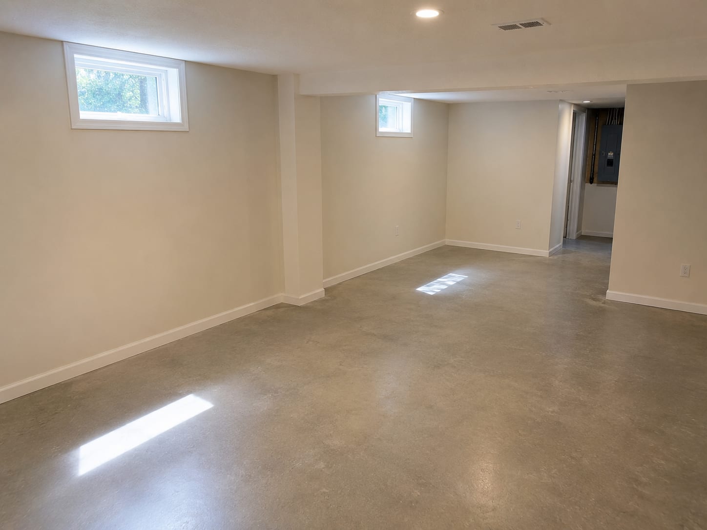 Clean finished residential basement in a New Jersey home after completed mold remediation showing fresh drywall, painted walls, and dry concrete floor