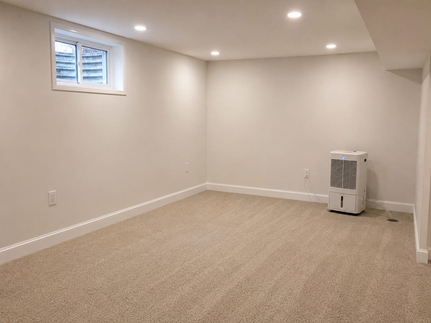 Clean restored basement interior in a New Jersey home after completed mold remediation showing fresh drywall installation new paint and dehumidifier running
