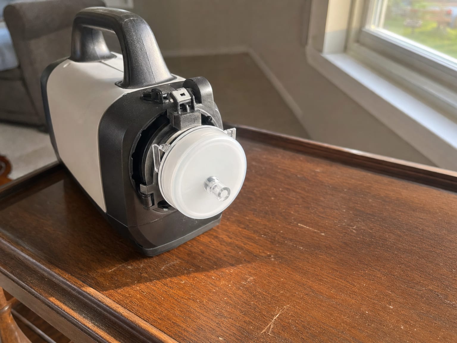 Air quality sampling pump and cassette resting on a finished basement floor beside a dehumidifier in a New Jersey home